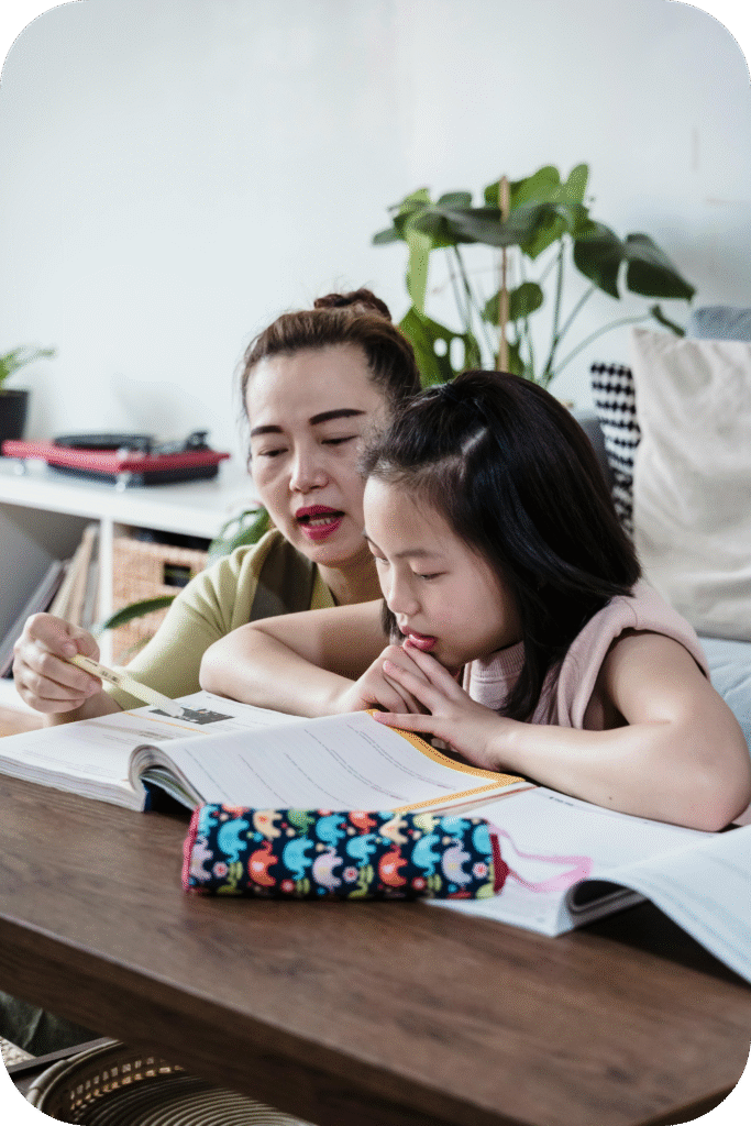 Parent guiding a child with writing homework at home